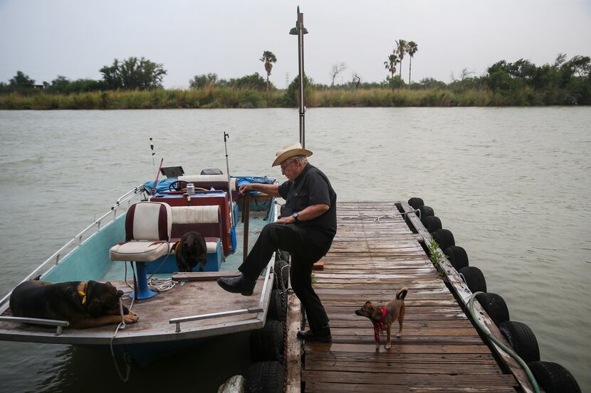 Father Roy Snipes boards his river boat before going out on the Rio Grande.