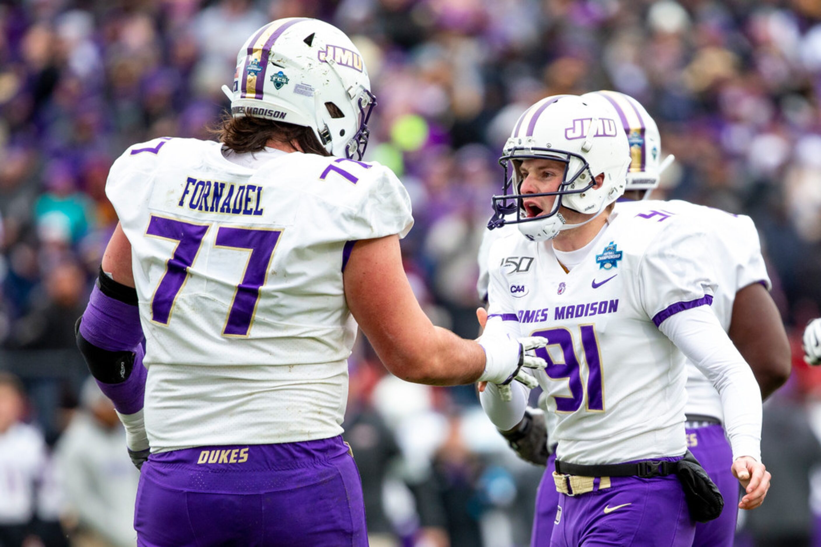 James Madison place kicker Ethan Ratke (91) is congratulated by offensive lineman Liam...