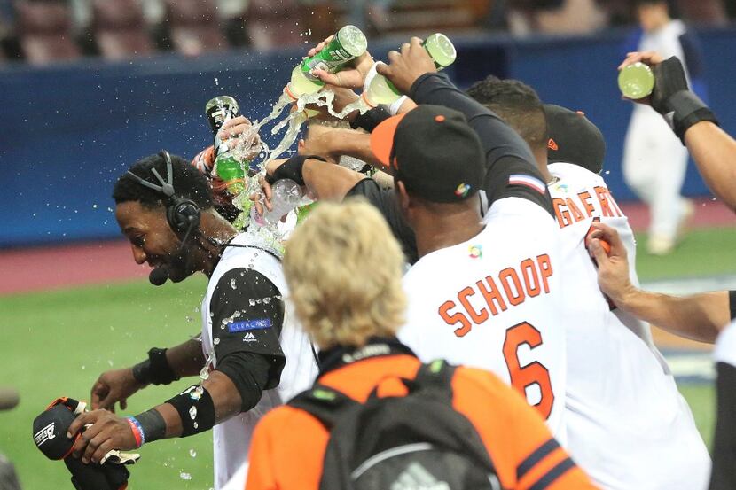 Netherlands's players pour liquid on  Jurickson Profar to celebrate after winning against...