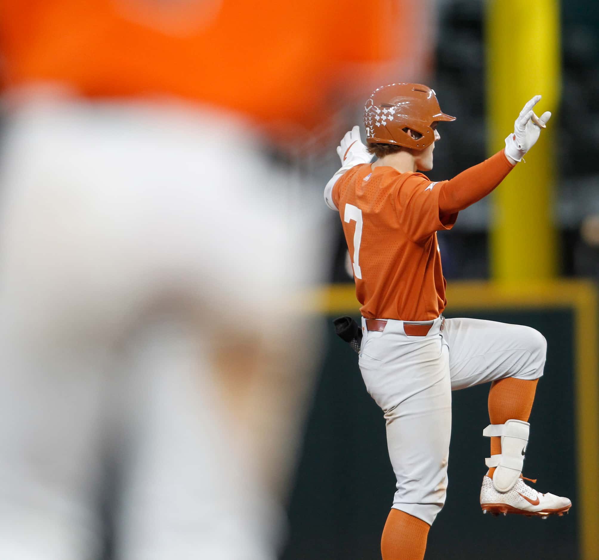 Texas Longhorns outfielder Douglas Hodo lll (7) gestures back to the team dugout as he...
