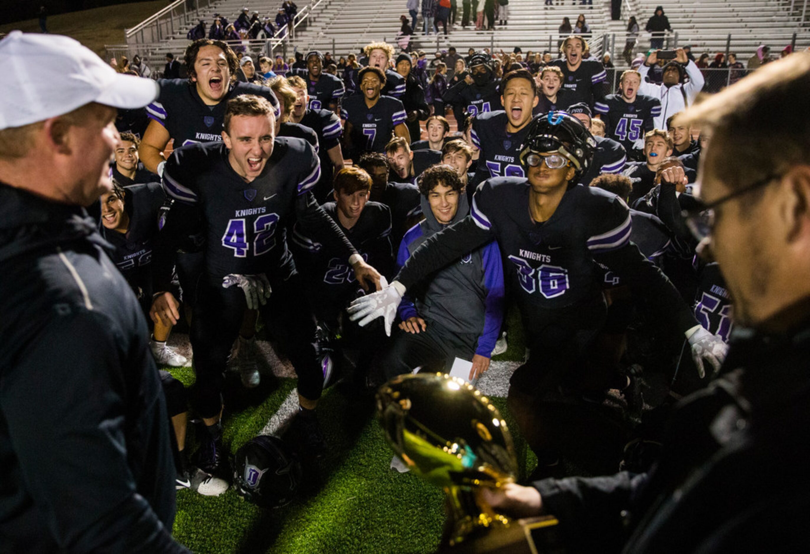 Frisco Independence football players react to receiving the bi-district championship trophy...