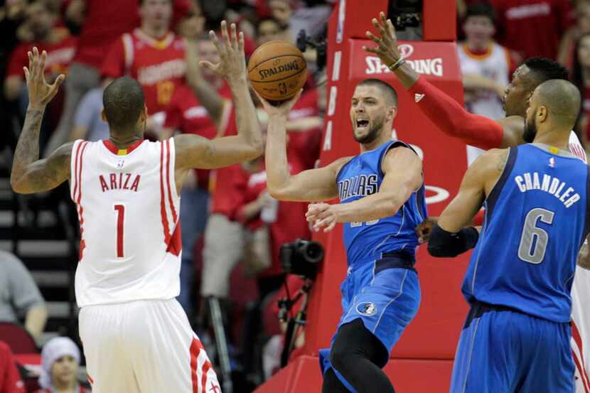 Dallas Mavericks forward Chandler Parsons (25) looks to pass out as he is defended by...