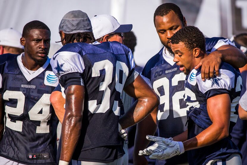 Dallas Cowboys defensive end Jeremy Mincey (92) puts his arm around defensive back Tyler...