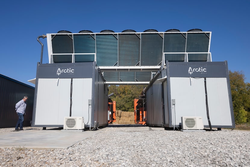 A tour group checked out storage buildings where bitcoin mining units are cooled by...