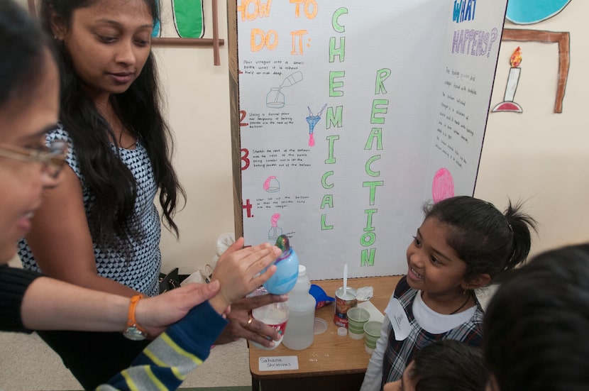 Show Shrinivas, second from left helps her daughter Shana Shrinivas, 5, right, demonstrate...