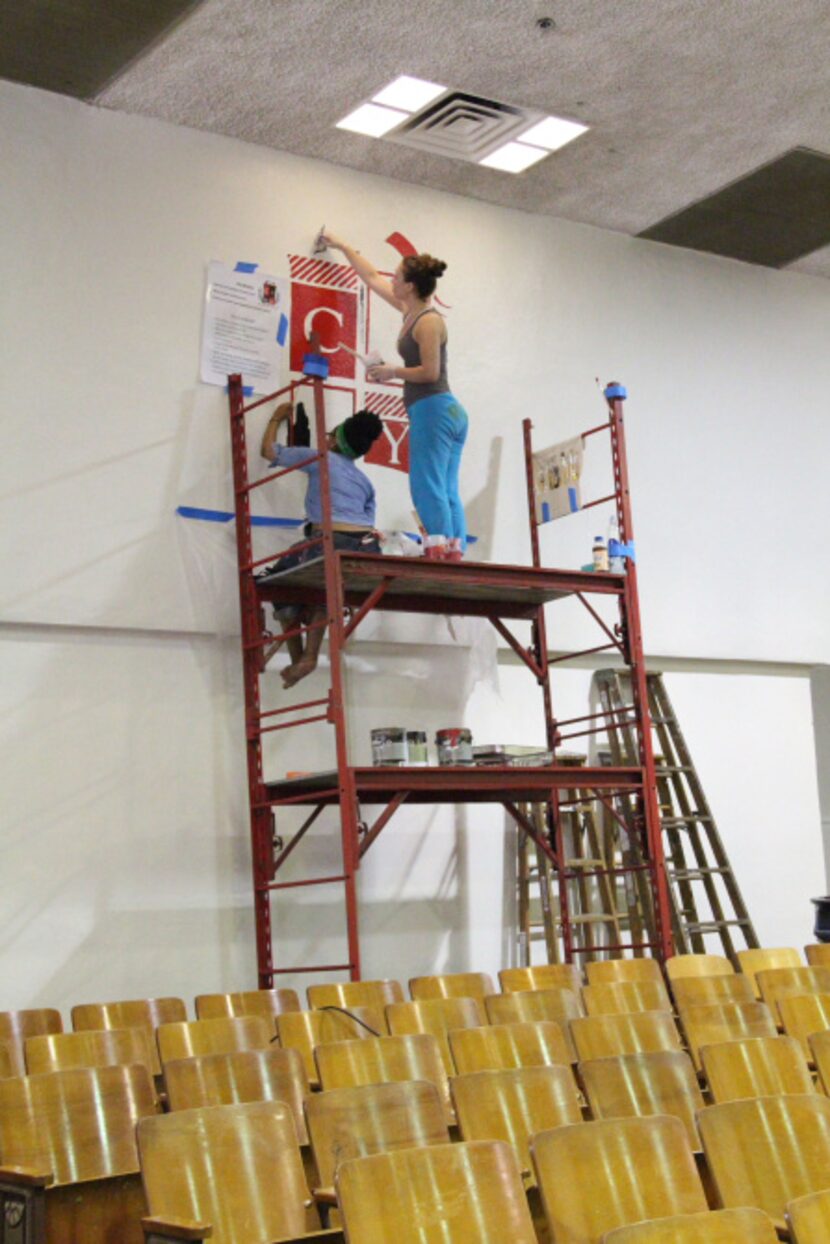 Tumi Mphahlele (left), 19, and Marissa Miller, 22 repaint the school's crest in the...