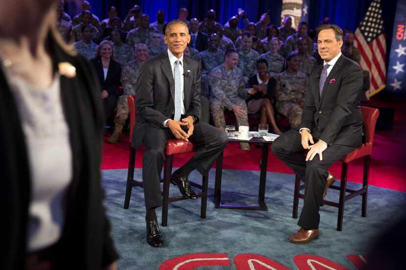President Barack Obama and CNN's Jake Tapper at a town hall with military personnel and...