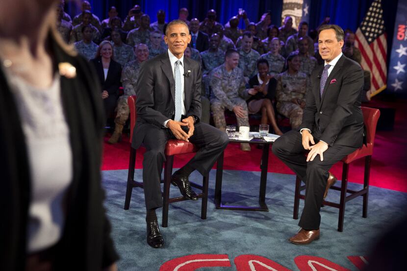 President Barack Obama and CNN's Jake Tapper at a town hall with military personnel and...