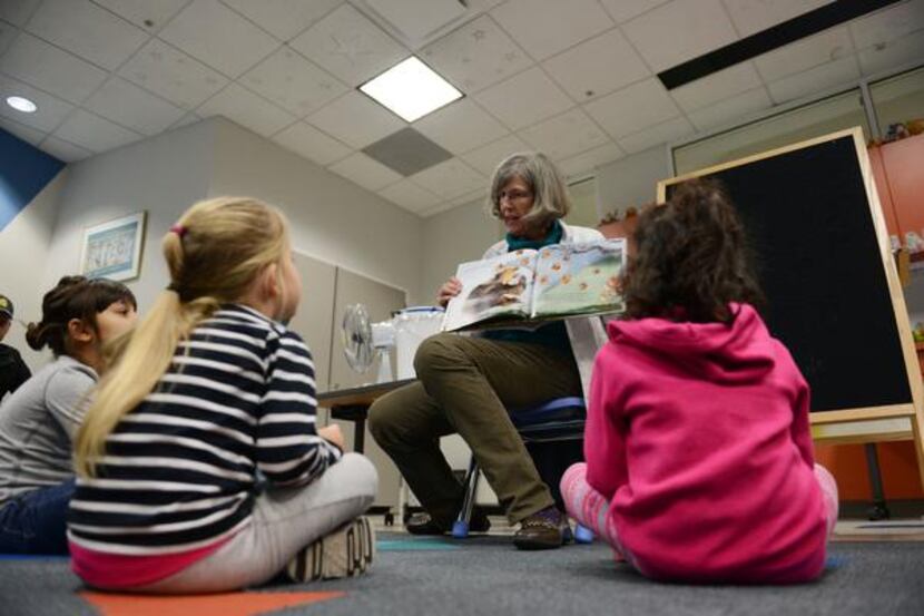 
Librarian Betsy Merrill reads to children during Family Storytime at William T. Cozby...