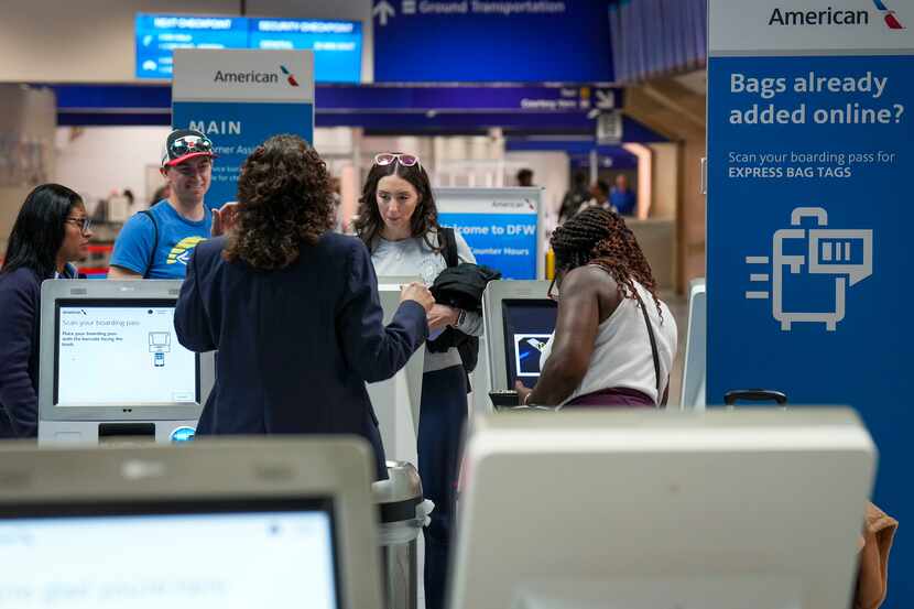 Passengers check baggage with American Airlines agents at Terminal C at DFW International...