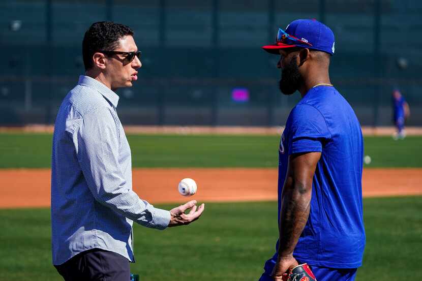 Texas Rangers general manager Jon Daniels tosses a baseball while chatting with outfielder...