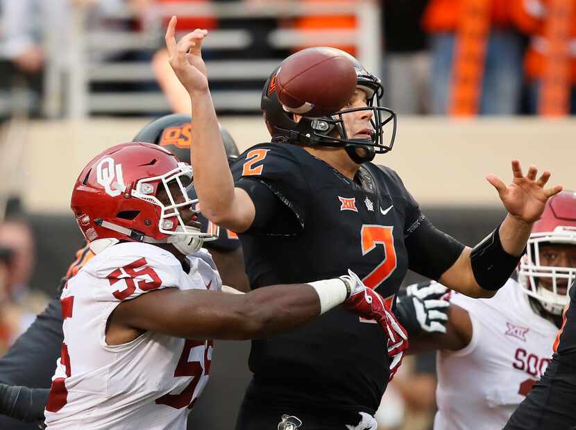 FILE - Oklahoma defensive lineman Kenneth Mann (55) strips the ball from Oklahoma State...