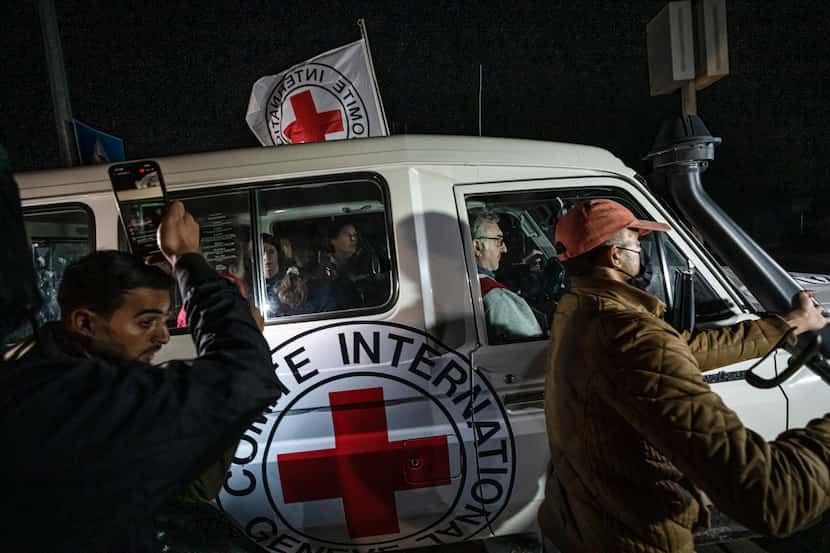 A Red Cross vehicle carrying Israeli hostages drives by at the Gaza Strip crossing into...