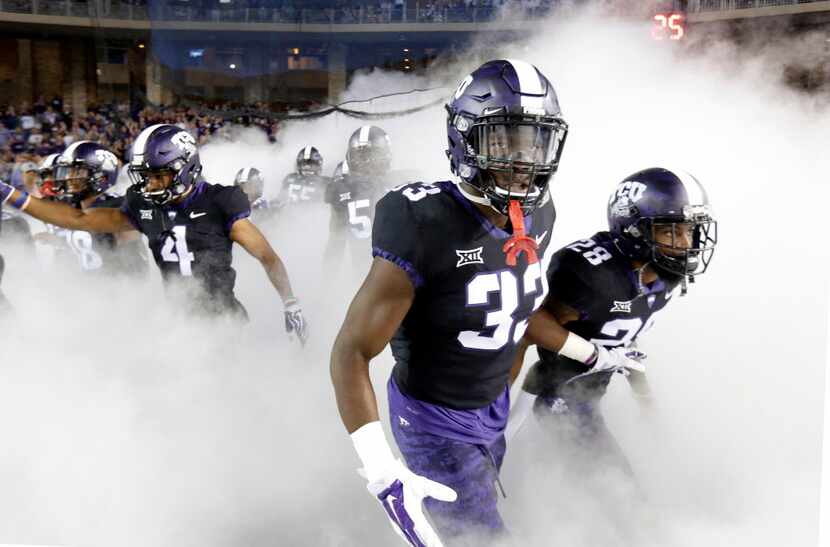 TCU Horned Frogs running back Sewo Olonilua (33) and his teammates race through the fog as...