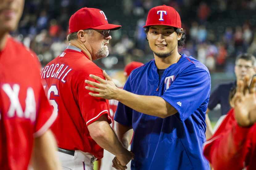 Texas Rangers starting pitcher Yu Darvish shakes hands with pitching coach Doug Brocail...