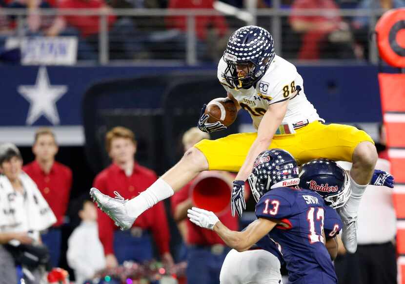 Highland Park's Cade Saustad (88) attempts to leap over Denton Ryan's Tamar Butts (6) as...