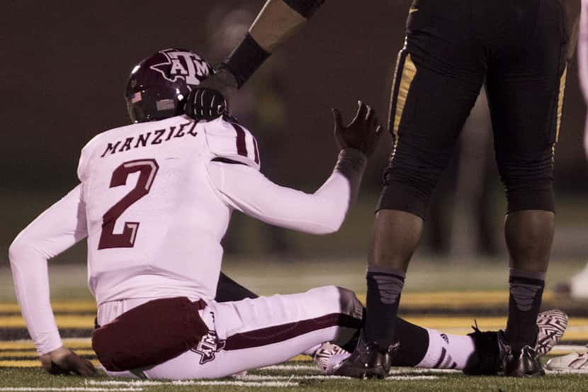 Texas A&M quarterback Johnny Manziel (2) is helped up off of the turf by Missouri defensive...