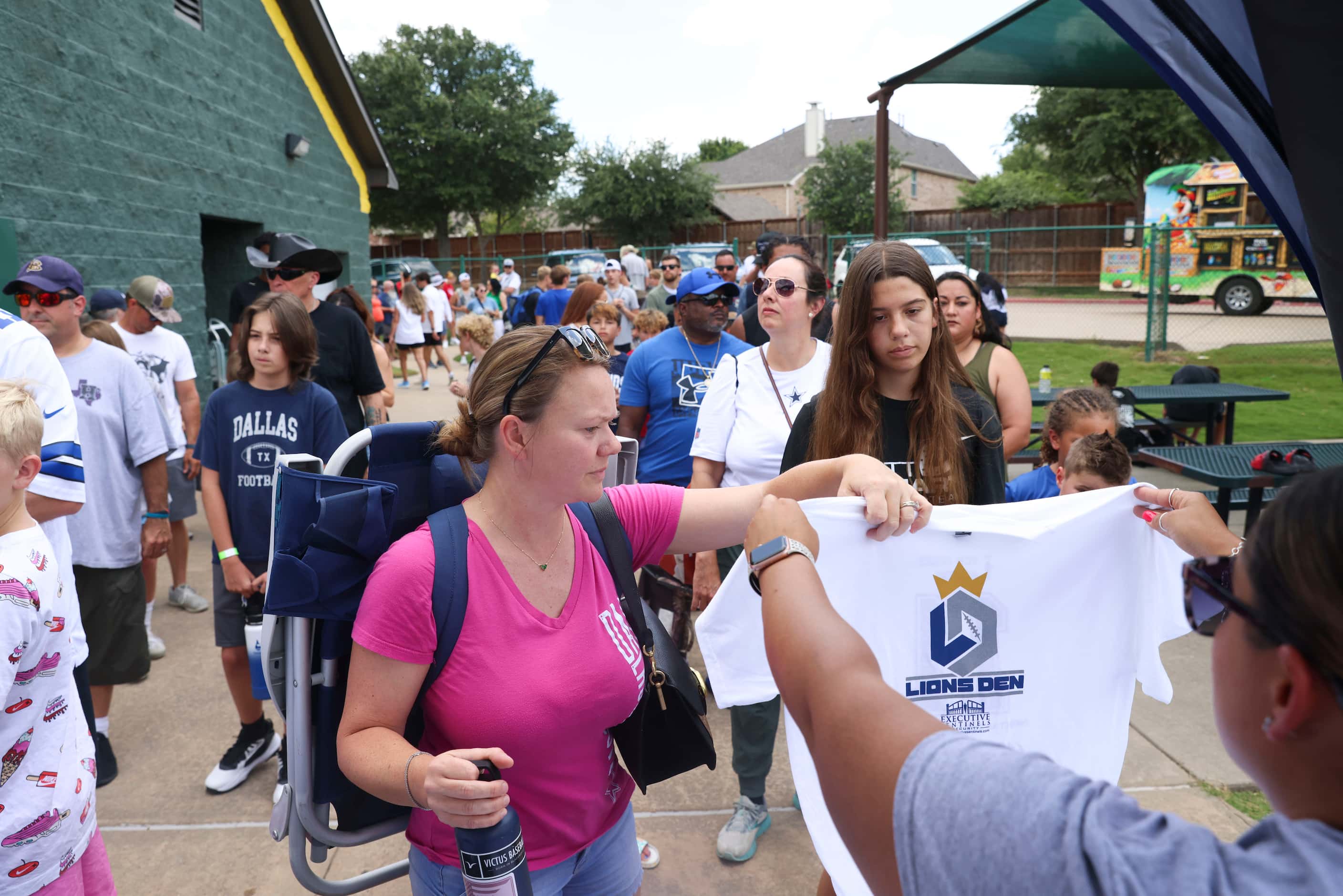 People stand check in  to enter Dallas Cowboys linebacker Micah Parsons youth football camp,...