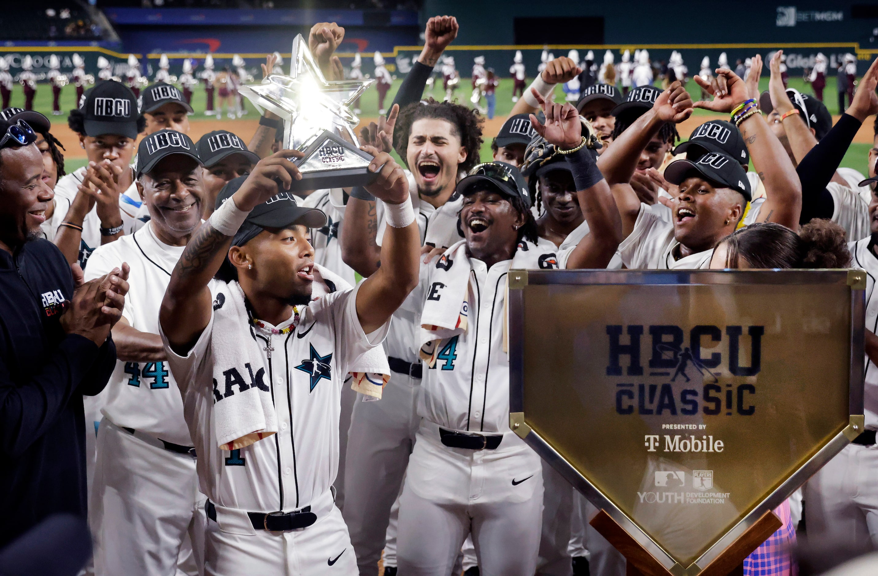 American League player Tiger Borom of Grambling State hoists the Most Valuable player trophy...