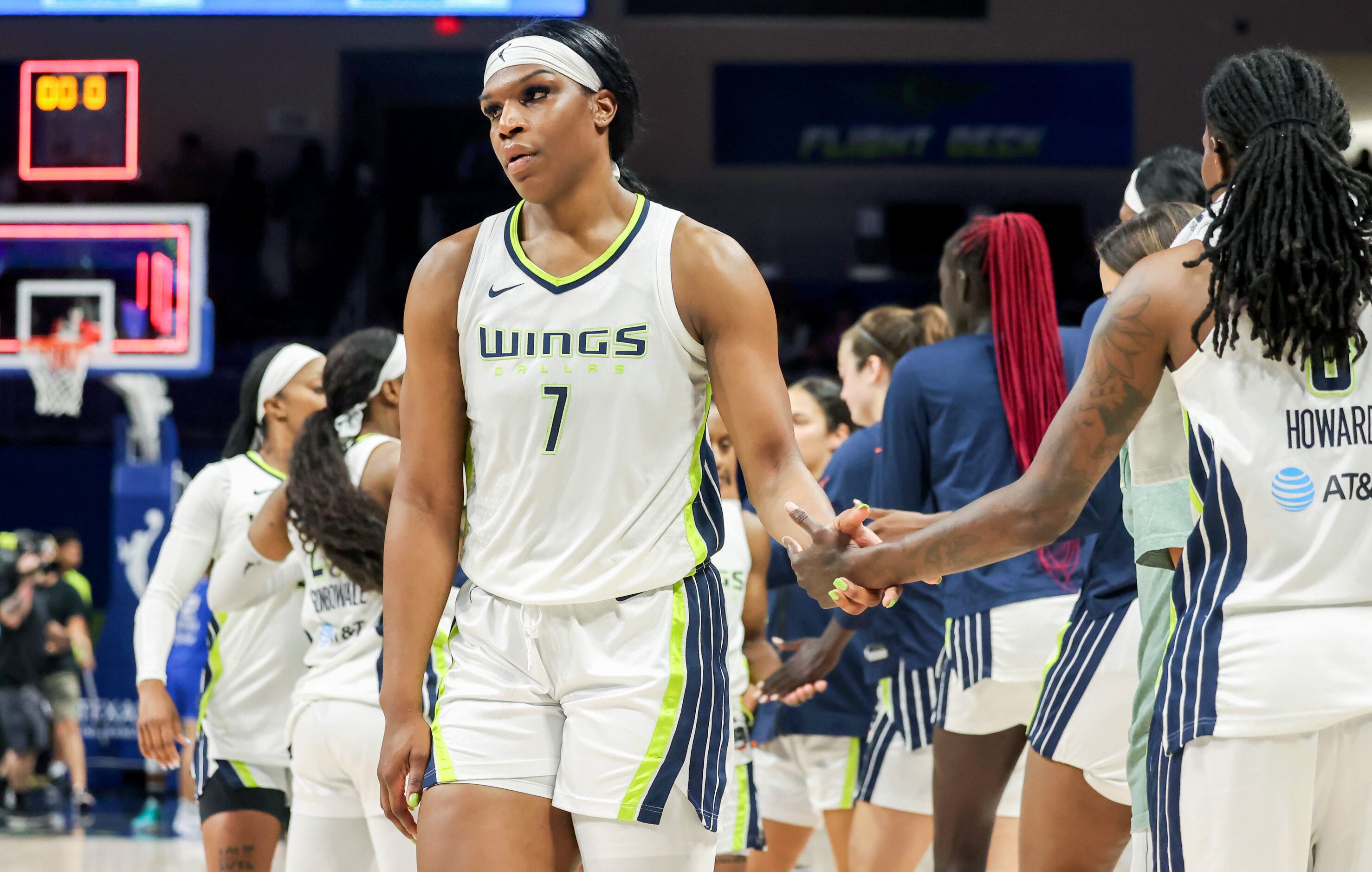 Dallas Wings center Teaira McCowan (7) looks at the court while shaking hands with teammates...