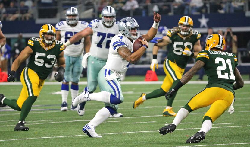 Dallas Cowboys quarterback Dak Prescott (4) threads his way through the Packers defense in...