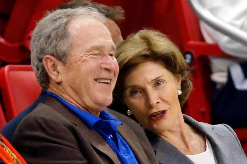 Former President George W. Bush shares a laugh with former First Lady Laura Bush during the...