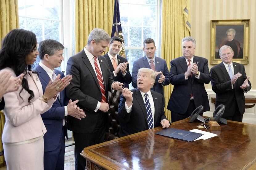  U.S. President Donald Trump gives the pen to Rep. Bill Huizenga (R-MI) after signing H.J....