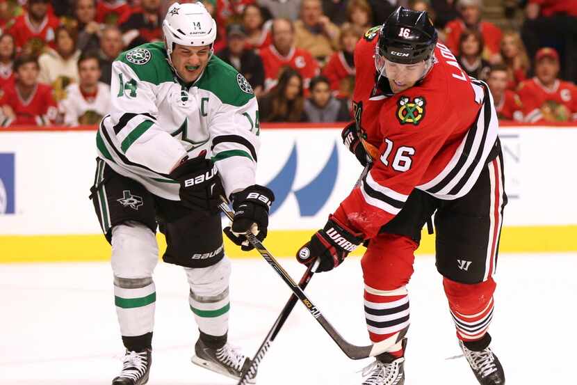 Chicago Blackhawks left wing Andrew Ladd (16) shoots the pack away from Dallas Stars left...