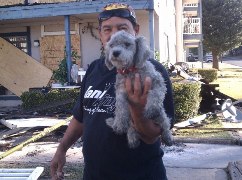 Juan Sauerec found his family's dog amid the ruins of their burned home Monday, a day after...