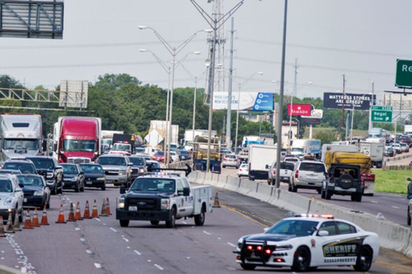 Traffic was routed off Interstate 35E as Texas Department of Transportation employees worked...