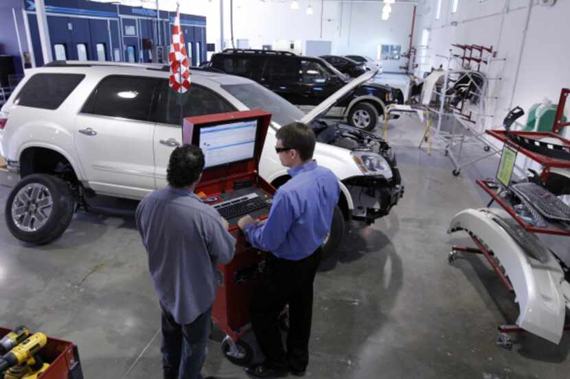 Technician Tad Waymire (left) works with Troy Ash, body shop manager at Caliber Collision...
