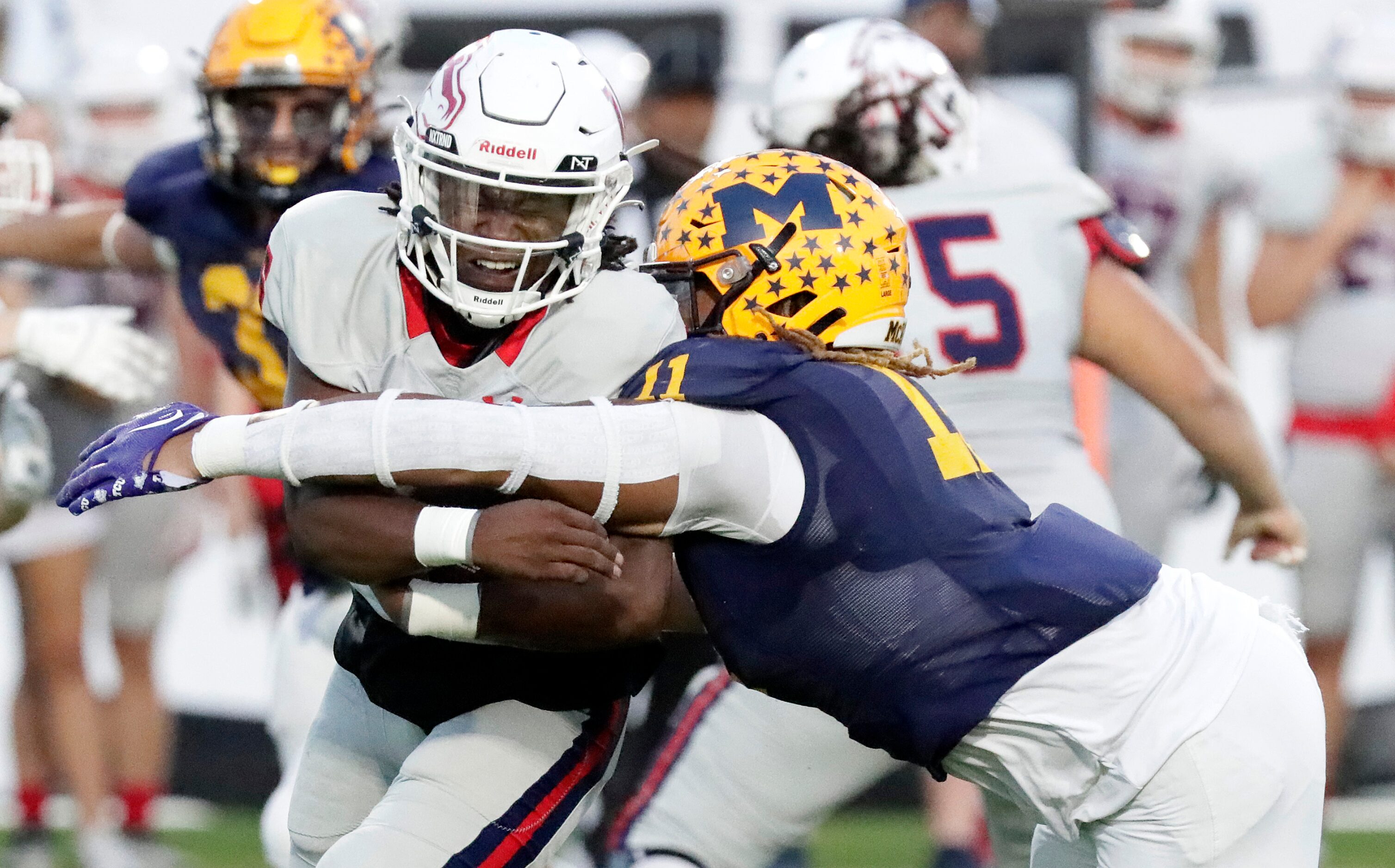 McKinney Boyd High School quarterback Marcus Johnson (16) is hit by McKinney High School...