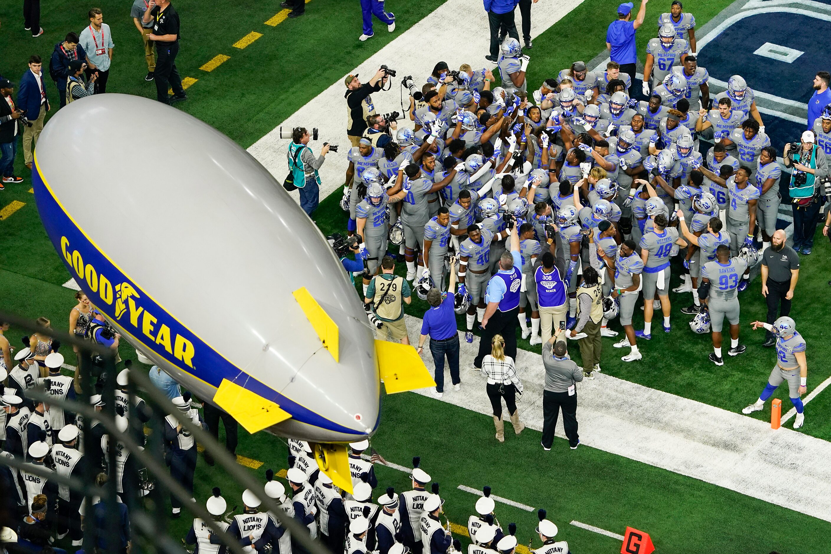 A miniature Goodyear blimp flies over Memphis players as they huddle before the Goodyear...