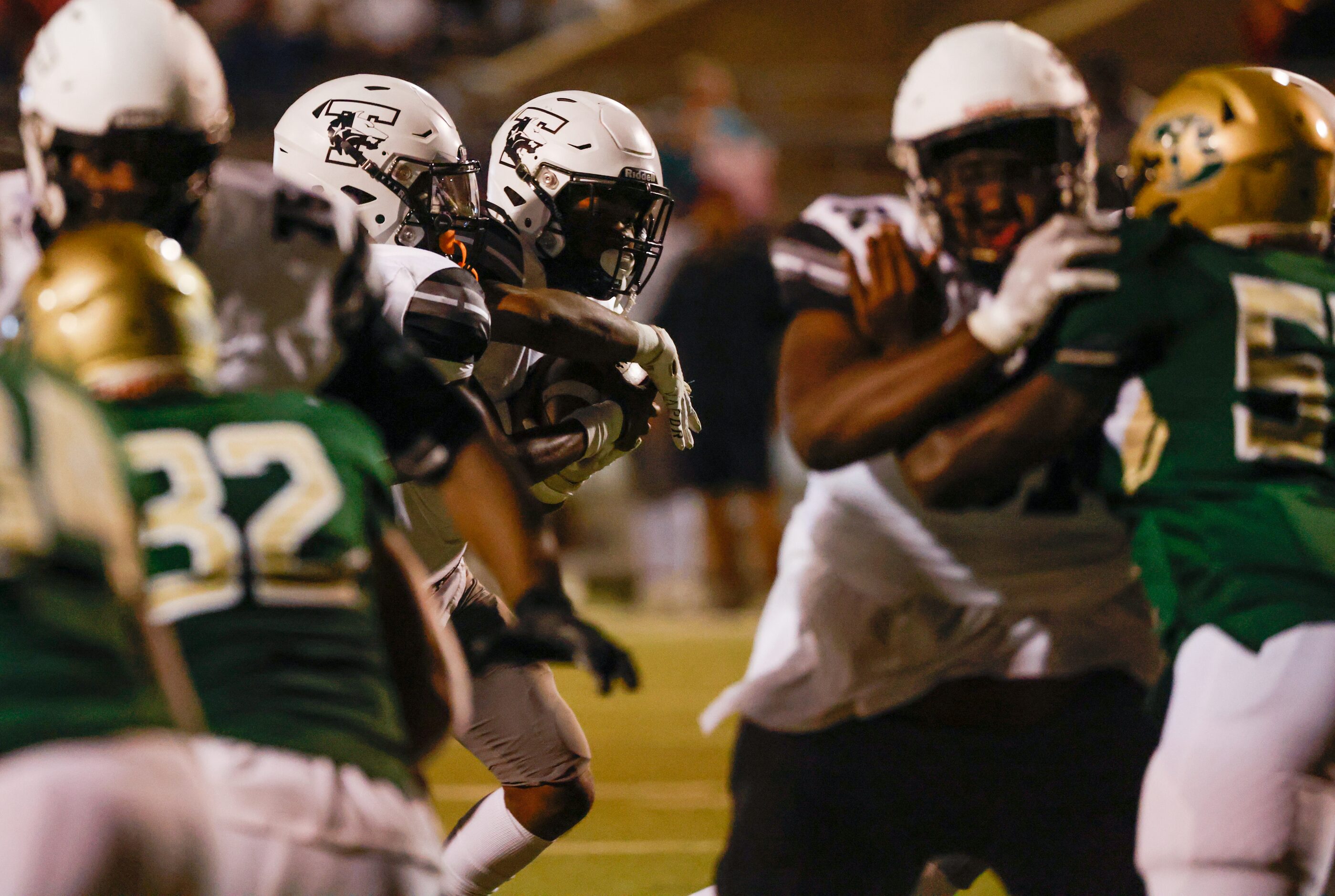 Mansfield Timberview quarterback Cameron Bates (3) reaches his hands around the ball in a...