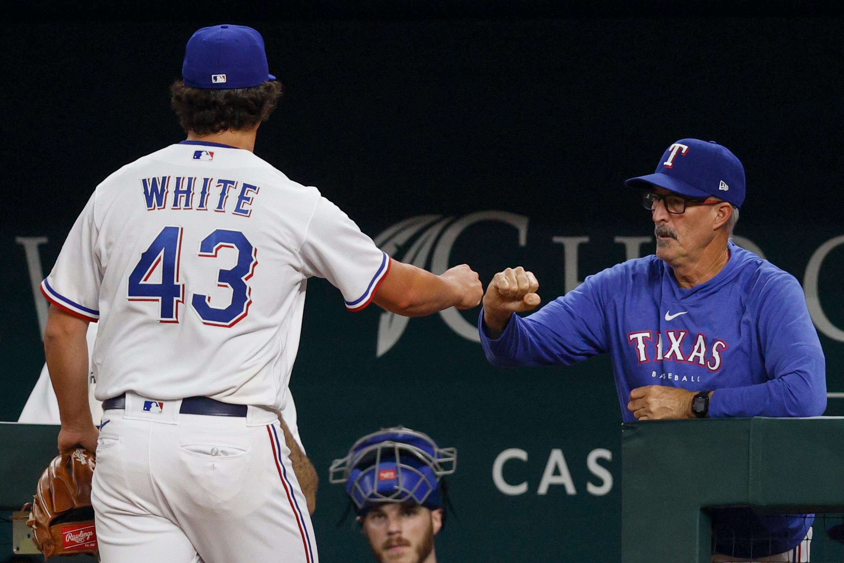 Texas Rangers relief pitcher Owen White (43) fist bumps pitching coach Mike Maddux (31)...