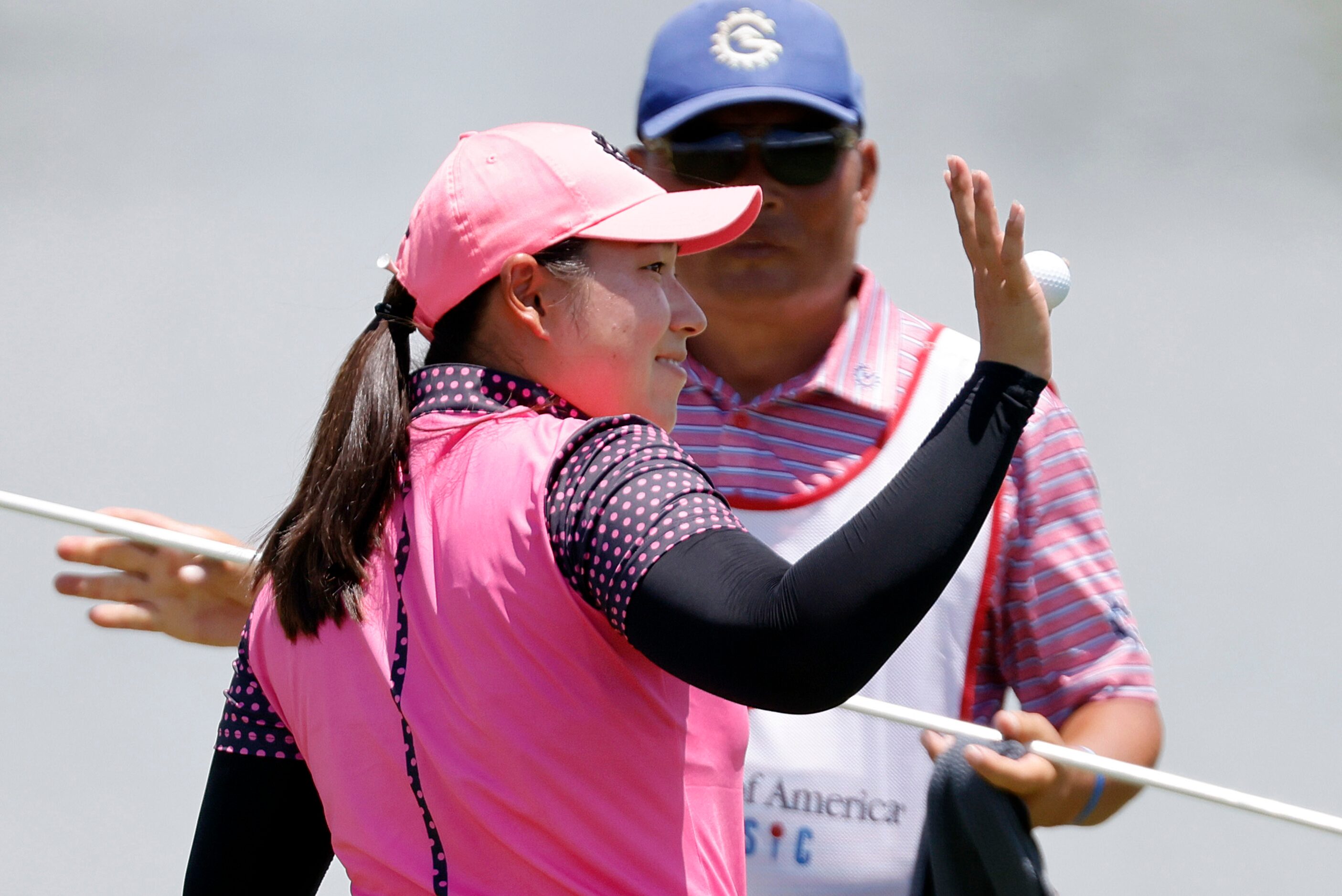 Professional golfer Min-G Kim waves to spectators after finishing her round on No. 18 during...