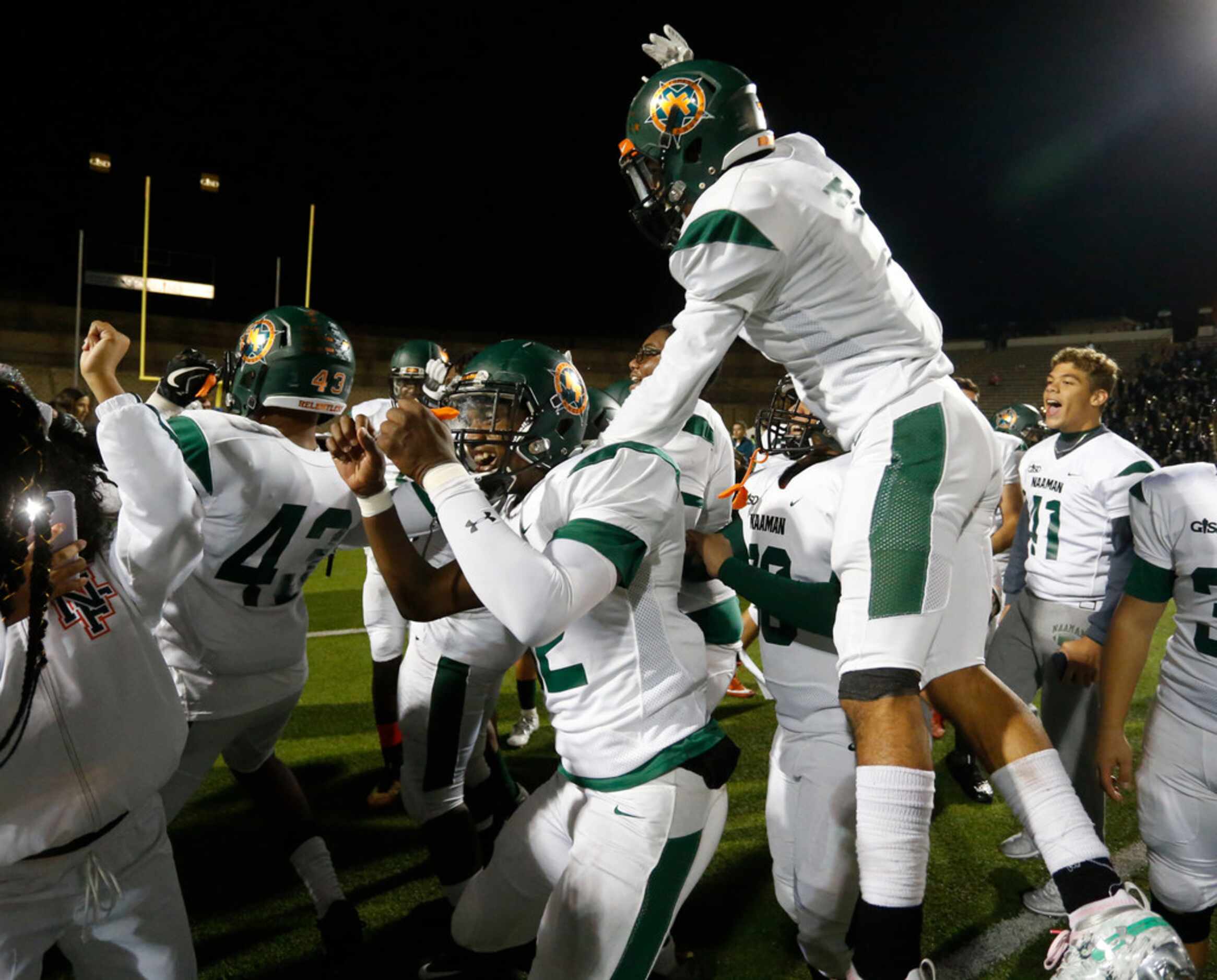 Naaman Forest players, including Shaft Davis (32), celebrate their 42-27 win over Lakeview...