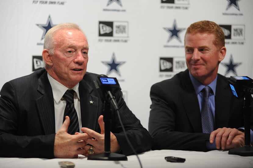 New Dallas Cowboys head coach Jason Garrett smiles next to owner and general manager Jerry...