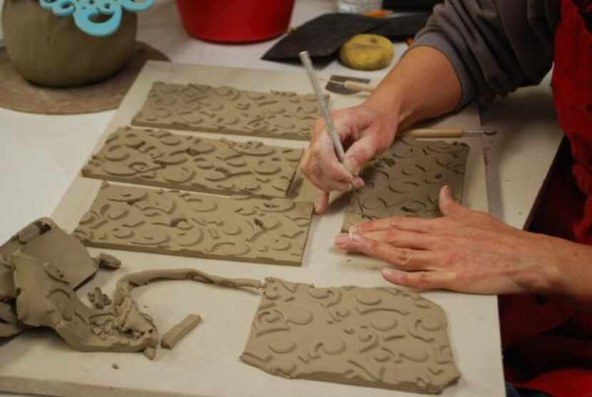 
Marcia Taylor cuts out a pattern on slabs of clay during a ceramics class. Taylor, a...