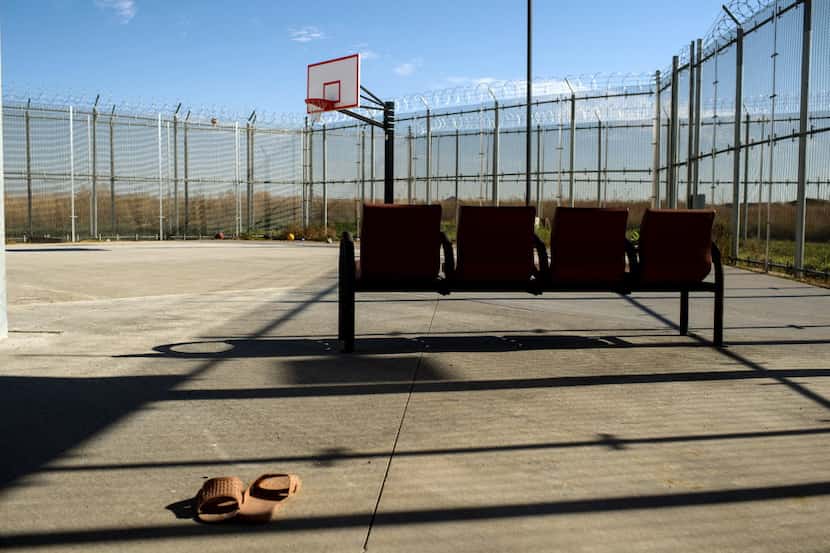 A forgotten pair of slippers sit on the basketball court behind barbed wire fence at the...