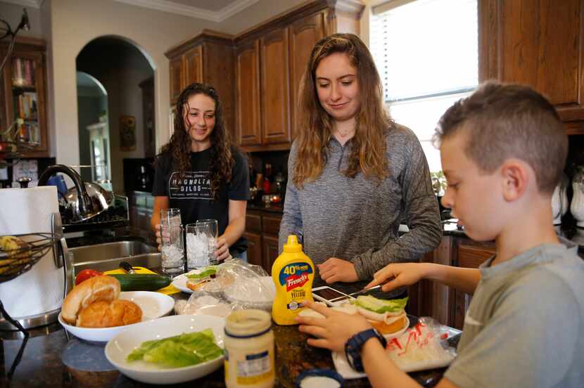 Heit family siblings Naomi (left), Lilly and Brandon prepare their lunches at home. “All...