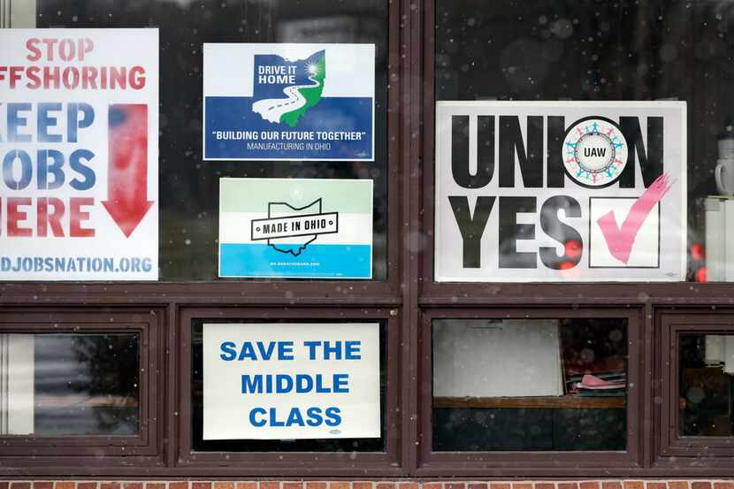In this Nov. 27, 2018 photo, signs hang from windows at the UAW Local 1112 union hall, in...