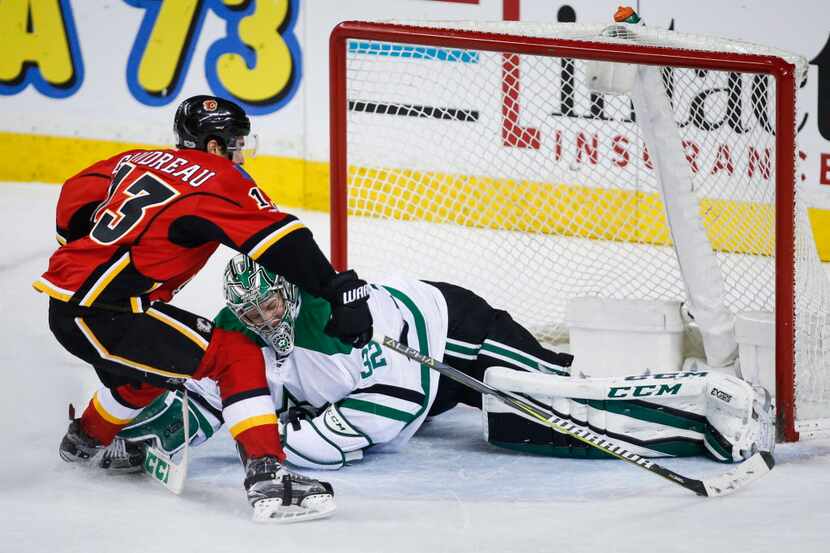 Dallas Stars goalie Kari Lehtonen, right, of Finland, blocks the net on Calgary Flames'...
