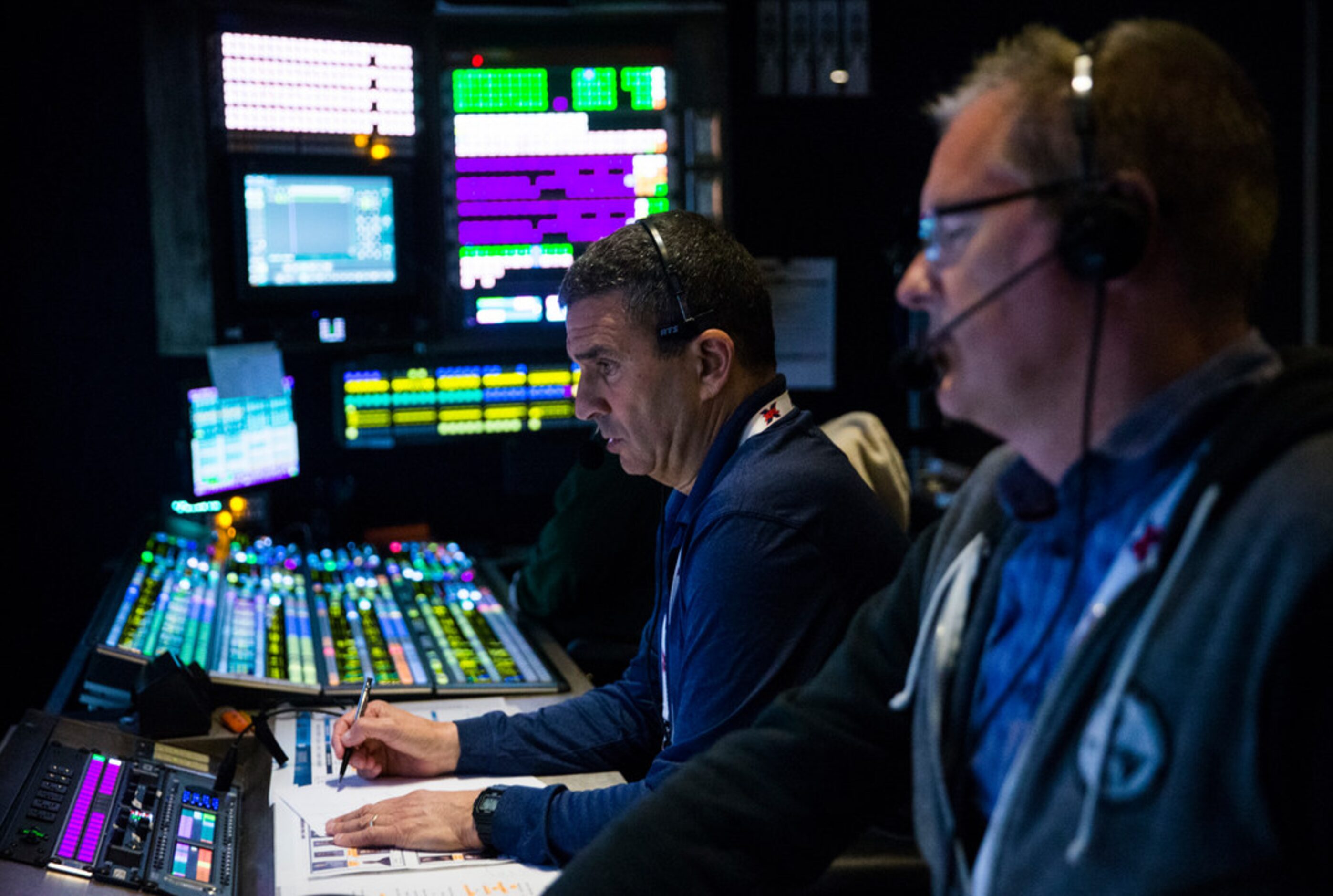 FOX Sports' Chuck McDonald (right) and Rich Russo (center) work in the control room during...