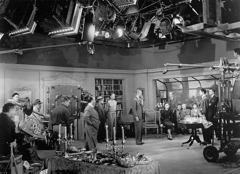 Director Alfred Hitchcock (center) rehearses star Jimmy Stewart and the cast as technicians...