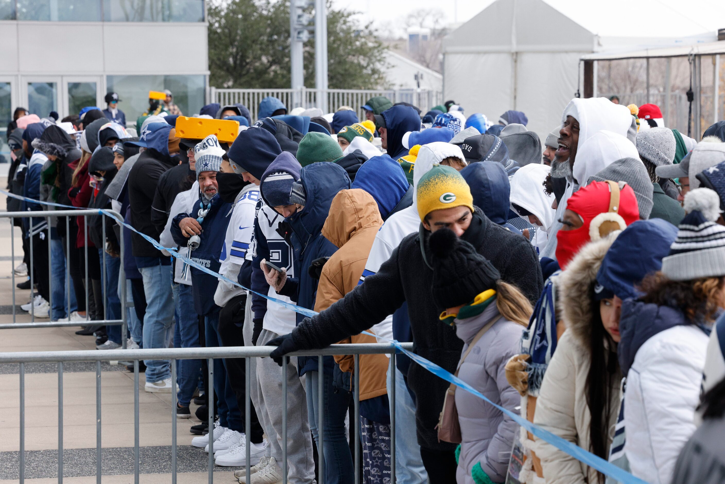 Dozens of fans wait outside AT&T Stadium for standing room only before an NFL wild card...