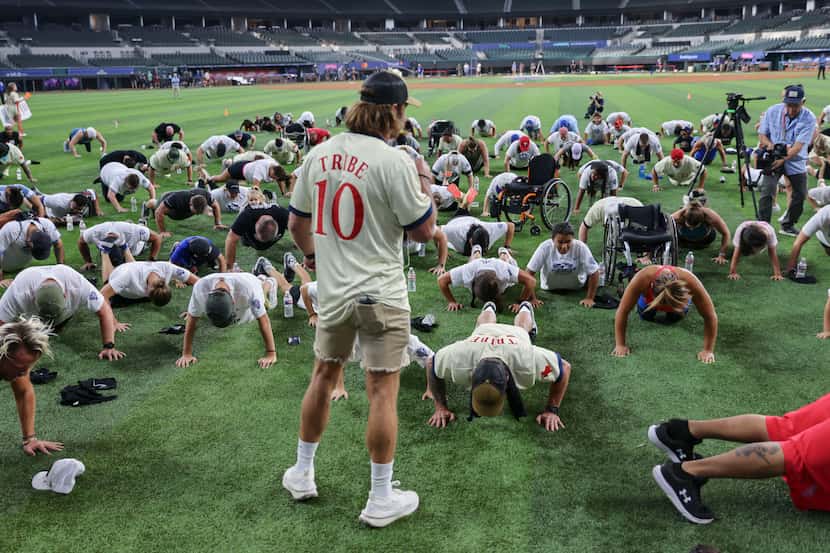 Participants take part in a push-up challenge during the All Star Weekend Workout by...