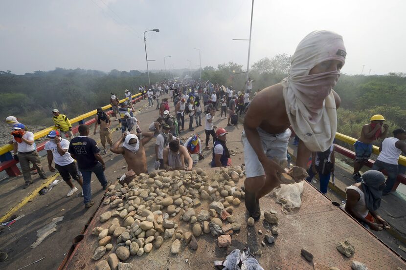 TOPSHOT - Demonstrators throw stones after a truck was set on fire at the Francisco de Paula...