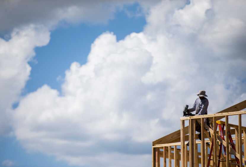 Construction workers frame new homes inside the Meritage Homes Villas at Las Colinas...