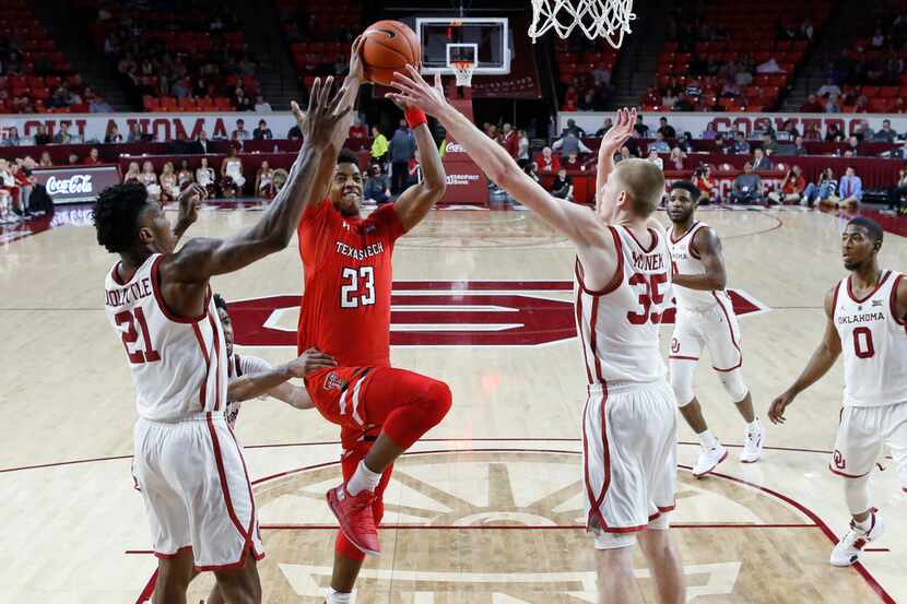 Texas Tech guard Jarrett Culver (23) goes to the basket defended by Oklahoma forward...